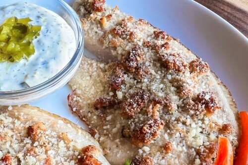 Golden brown fish fillets on a white plate. 