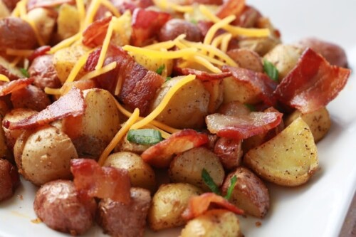 A large platter of roasted potatoes with crispy bacon