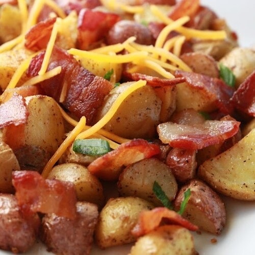 A large platter of roasted potatoes with crispy bacon