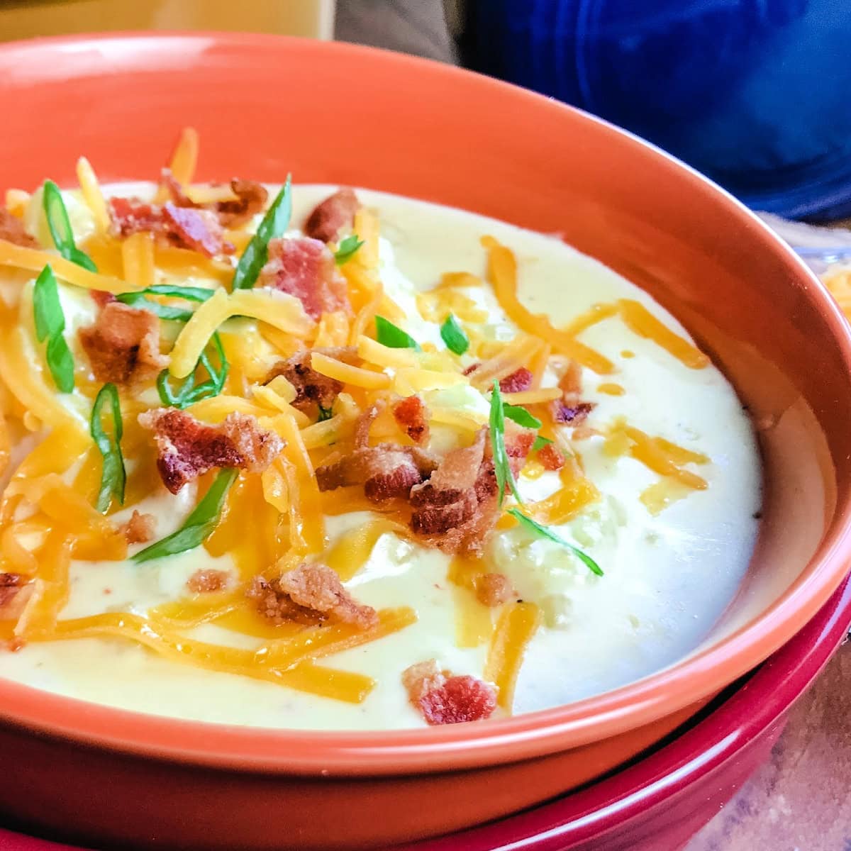 Easy Instant Pot Baked Potato Soup in a red bowl.