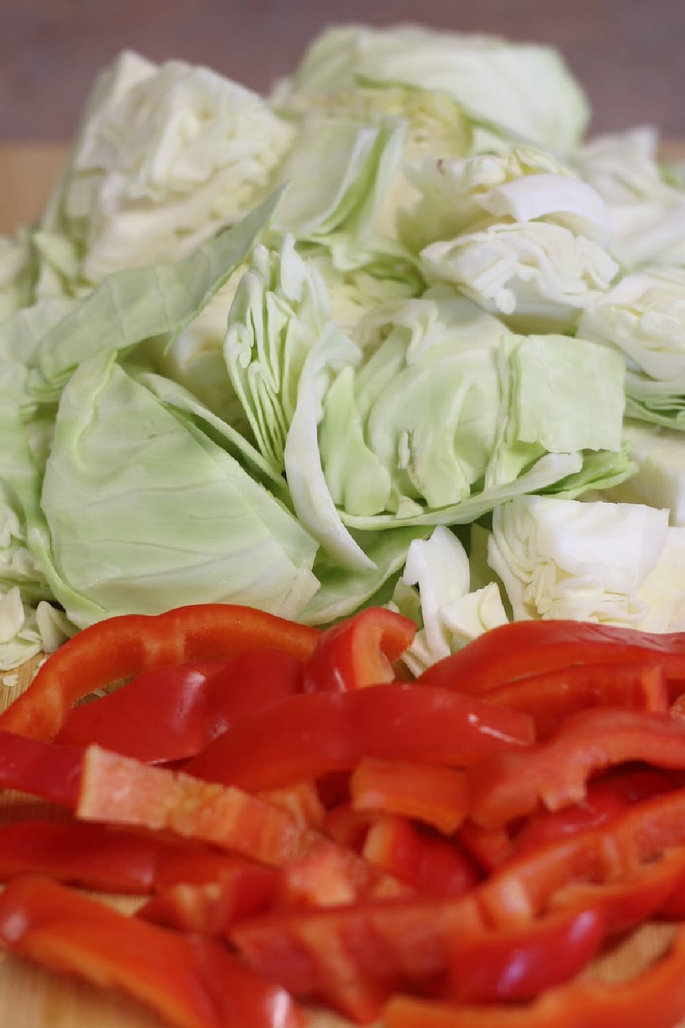 Cabbage cut into bite-size pieces and red bell peppers cut into strips. 