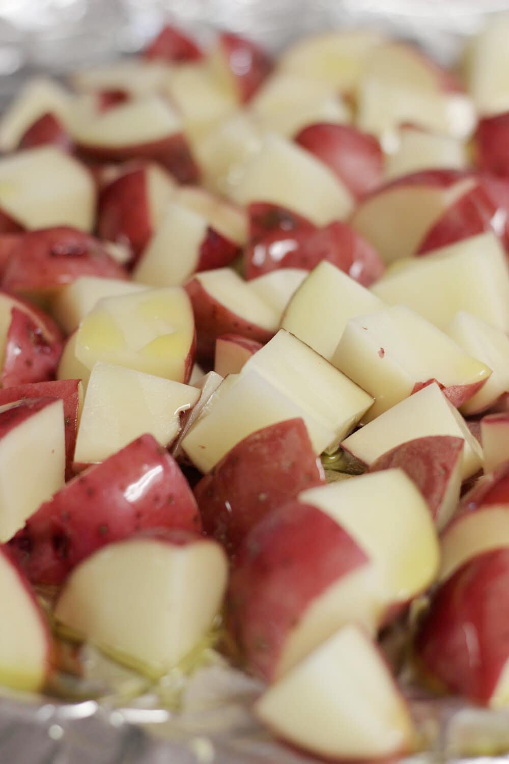 Red potatoes cut into chunks for a sheet pan meal. 