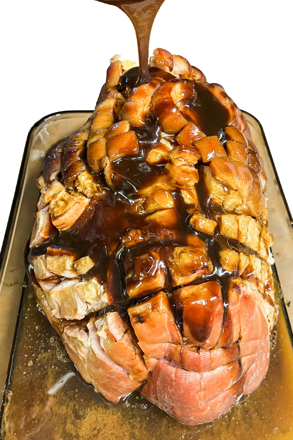 Sticky sauce being poured over a baked ham for the glaze. 