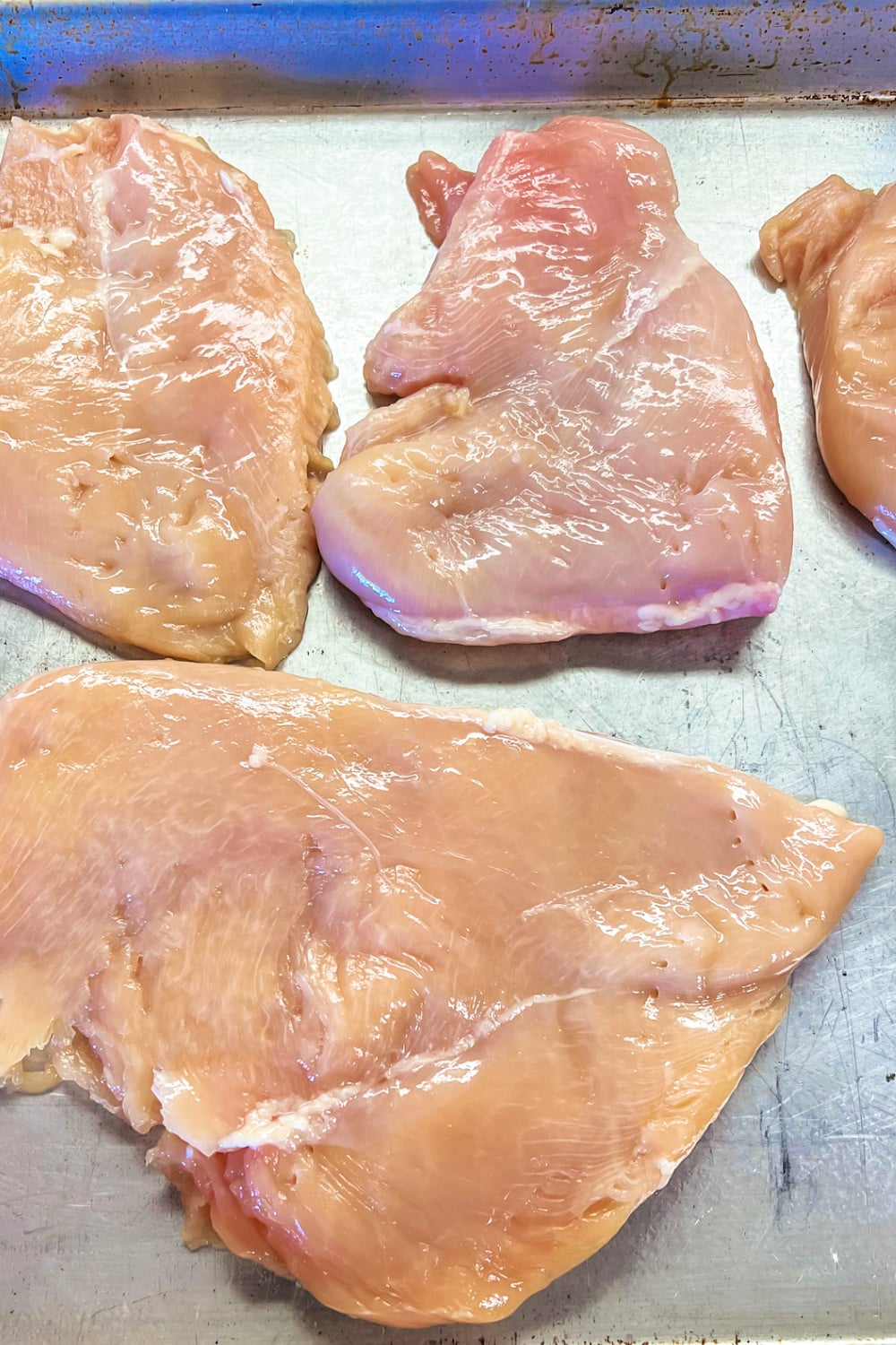 Pounded chicken breasts (cutlets) on a baking sheet. 