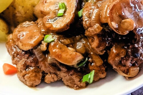 Delicious Hamburger Steak patties with brown gravy and mushrooms.