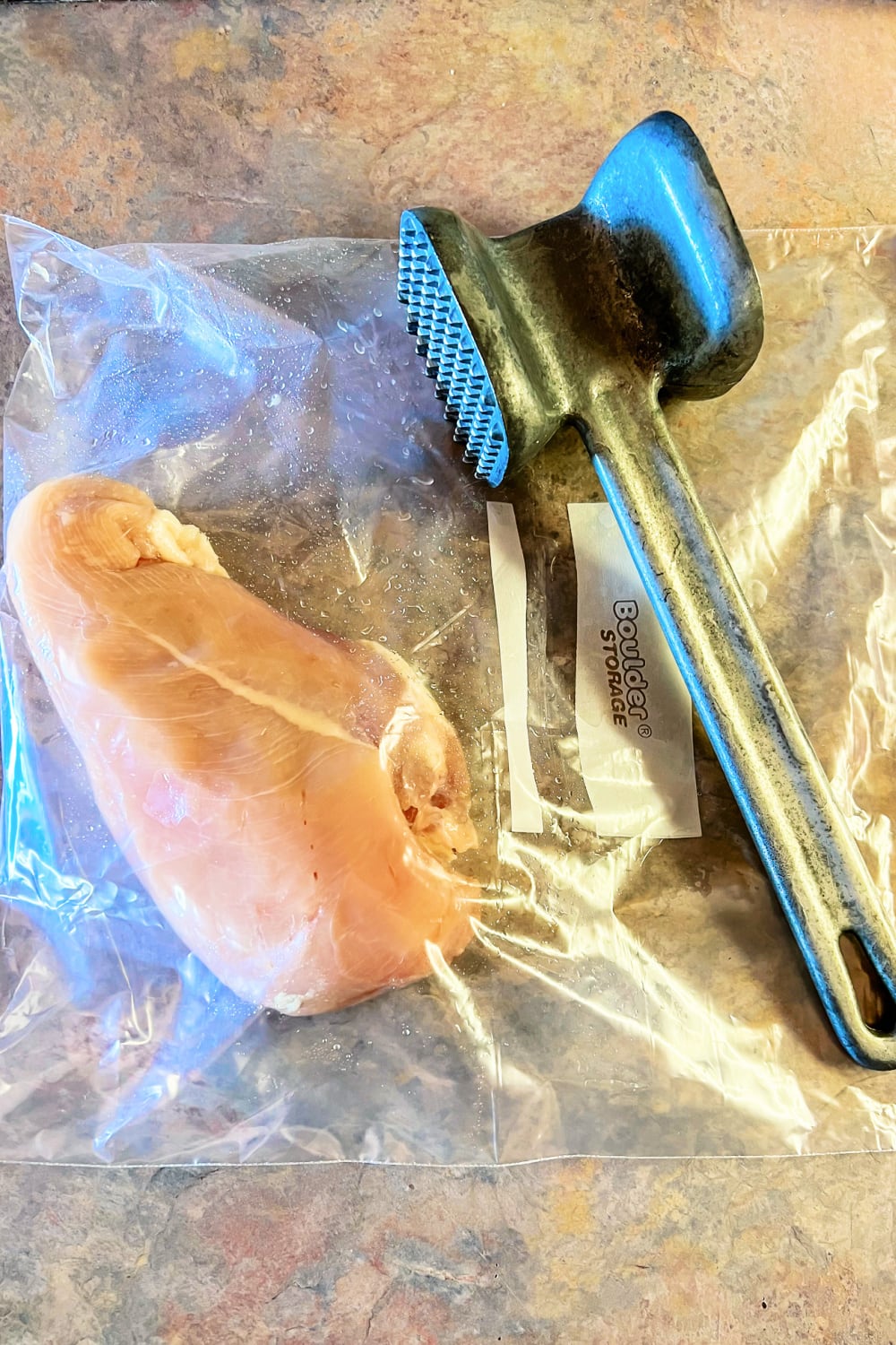 Boneless, skinless chicken breast in a gallon bag, ready to be pounded with a mallet. 