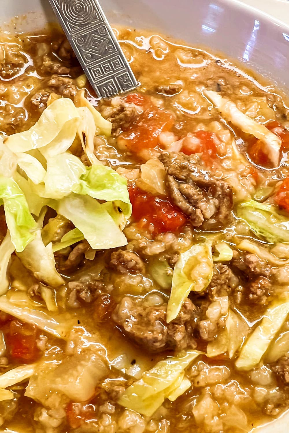 Instant Pot Cabbage Roll soup in a white bowl with a spoon. 