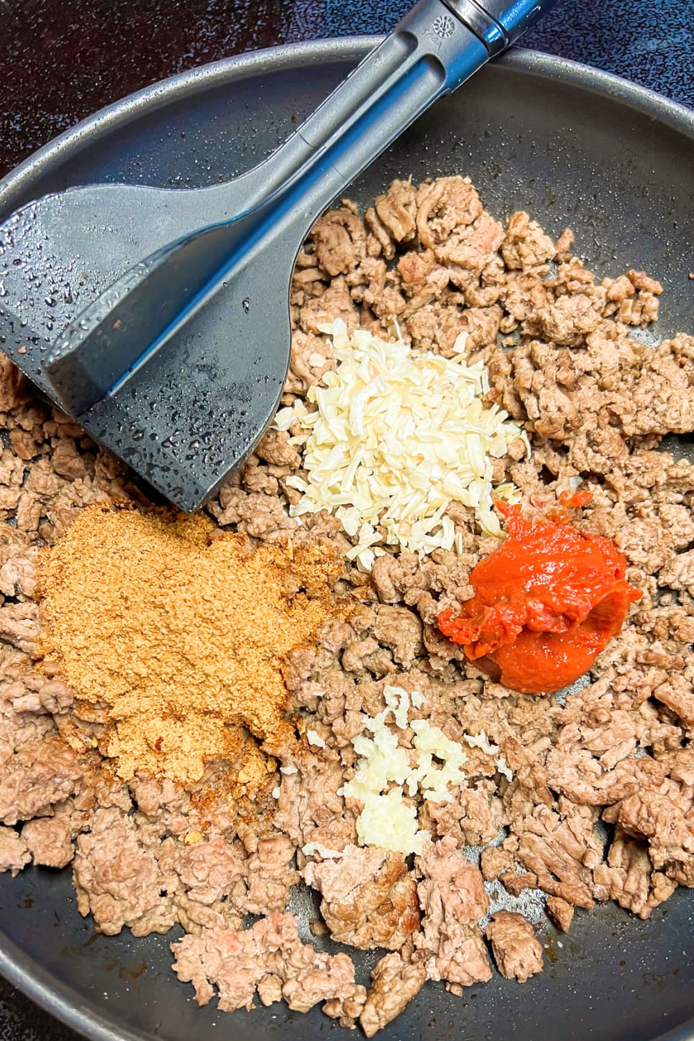 A skillet with ground beef and spices. 