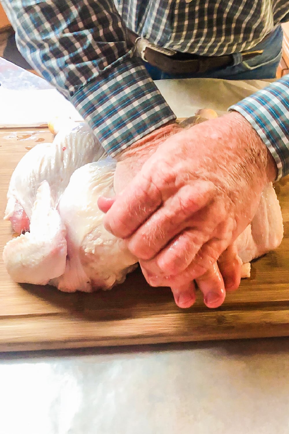 Pressing down on the chicken to flatten it. 