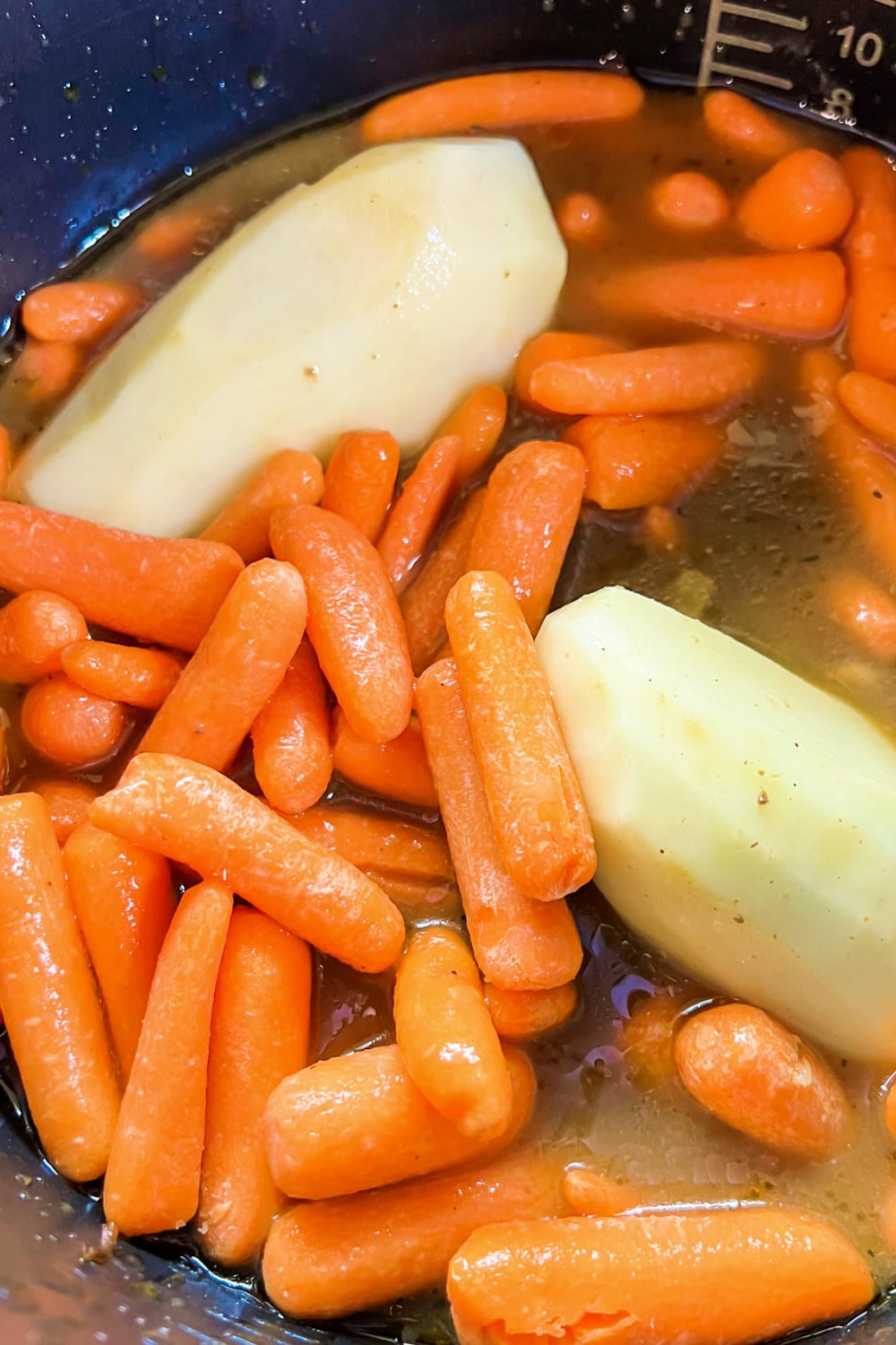 Peeled potatoes and baby carrots ready to be cooked. 