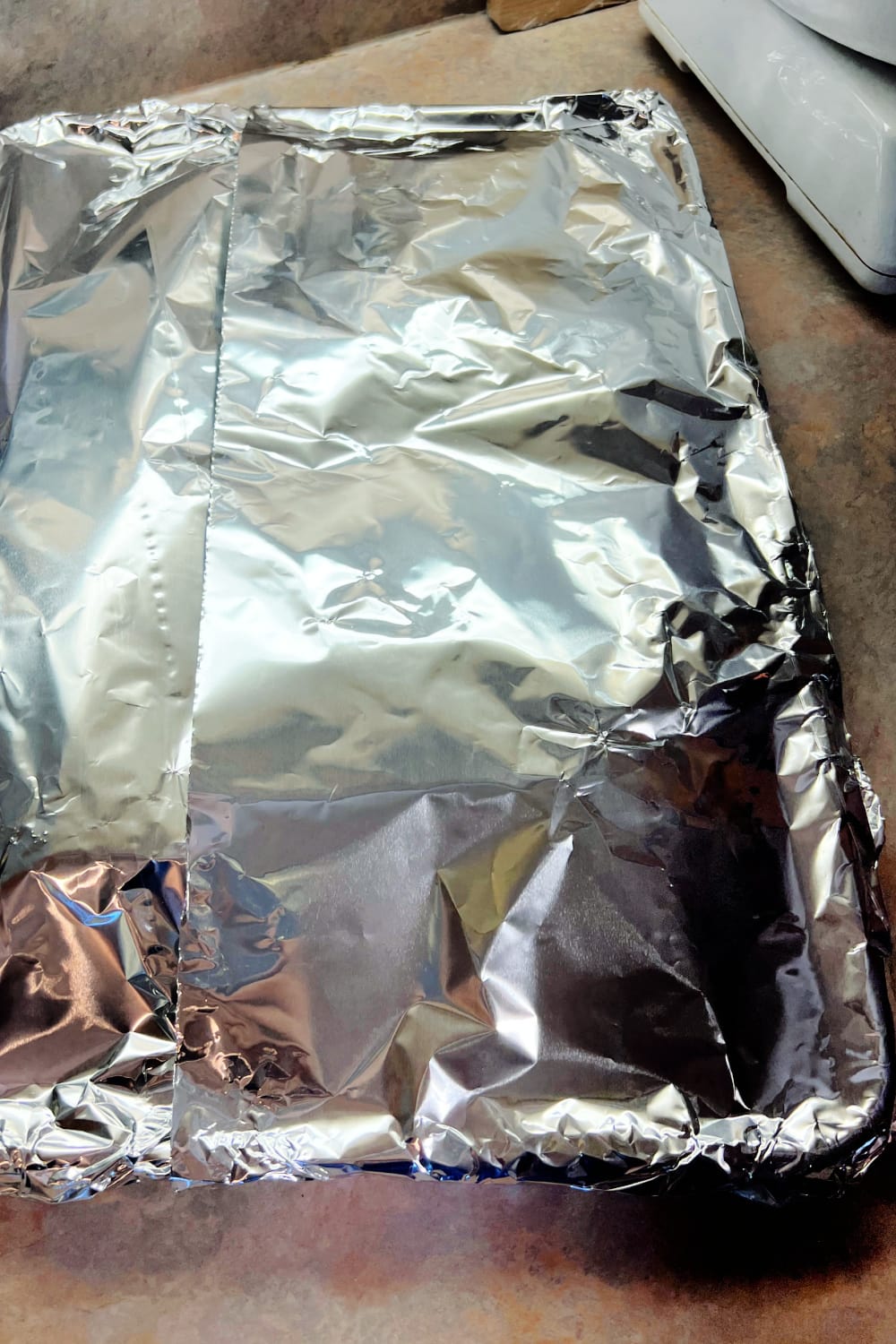 A sheet pan covered with foil, ready for the oven.