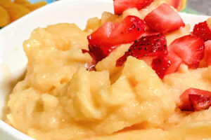 A white bowl loaded with frozen fruit sorbet.