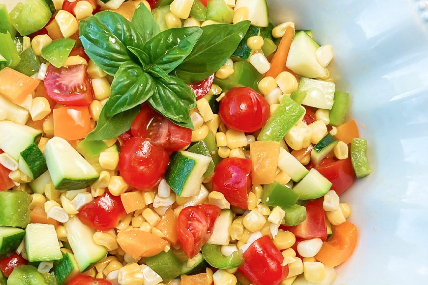 Marinated Corn Salad with Fresh Basil garnish on the side. 