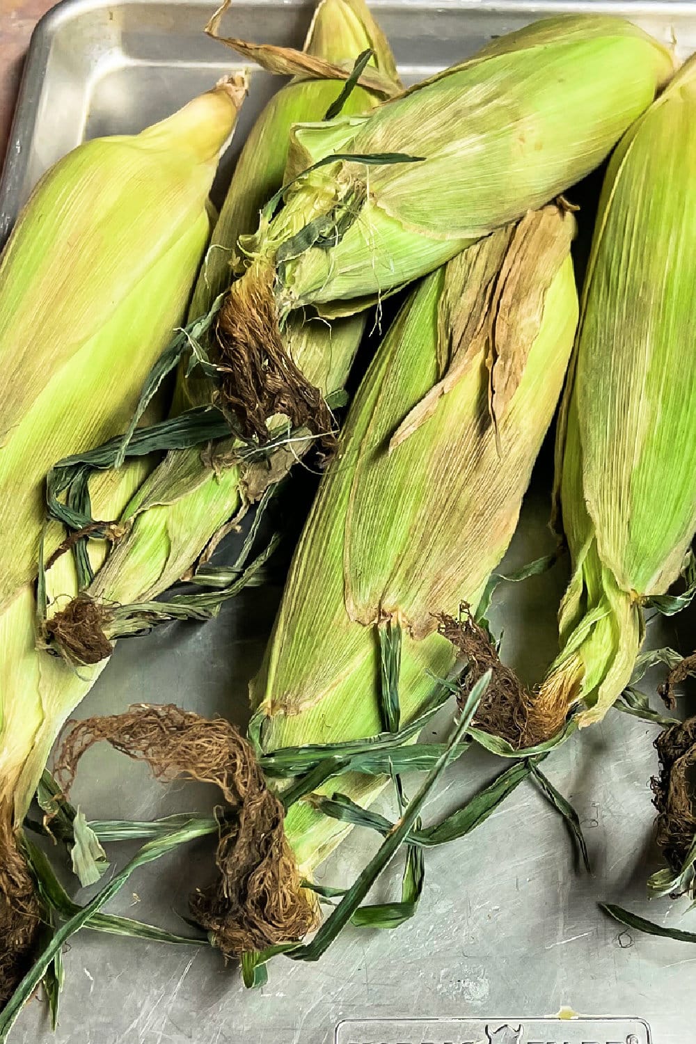 Ears of corn ready to be shucked and cooked. 