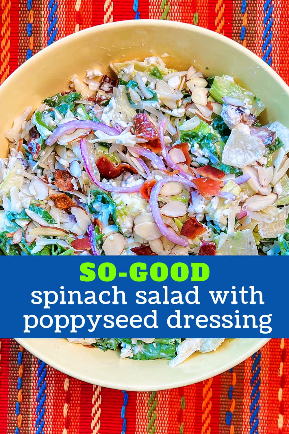 A serving bowl loaded with spinach salad and poppyseed dressing. 