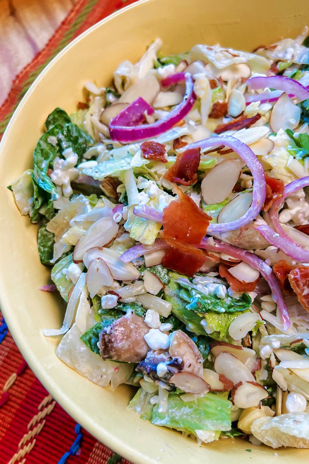 Light and refreshing spinach salad in a yellow serving bowl. 