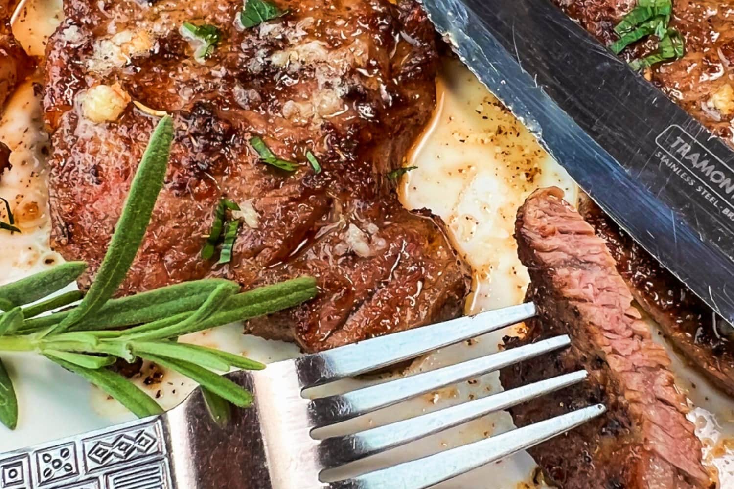 Garlic Butter Sizzle Steaks with a bite on a fork. 
