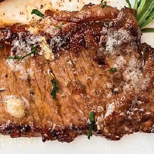 Medium rare butter garlic steaks on a platter.