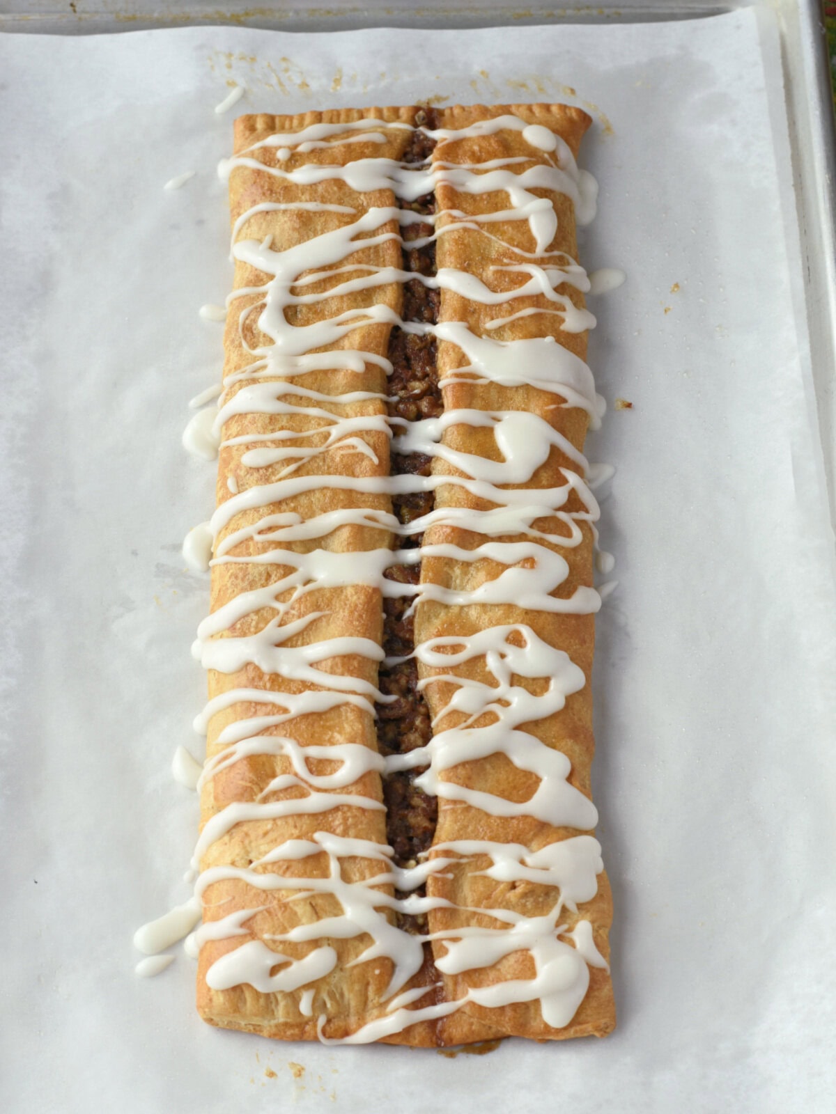 Cooked crescent roll dessert that is iced on a baking sheet. 