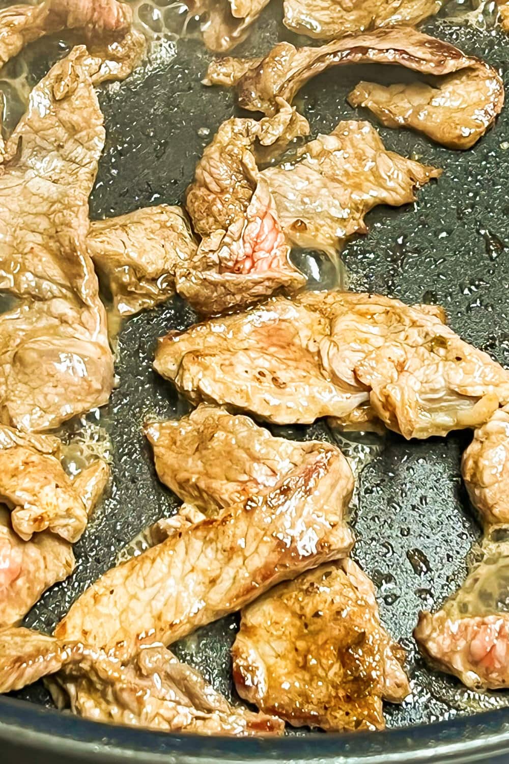 Cooked sizzle steak in a skillet, ready to be eaten. 