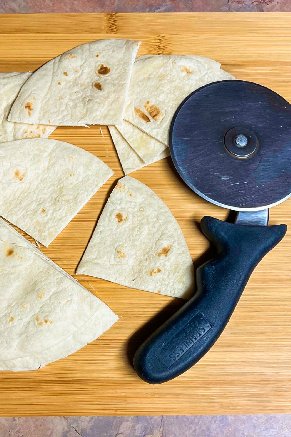 Flour tortillas cut into triangles with a pizza cutter. 