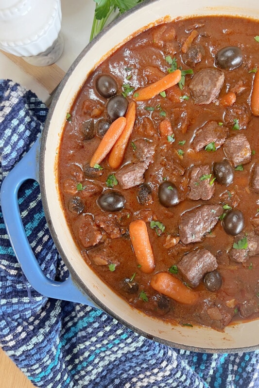 Thick and delicious, beef stew in a blue pot.