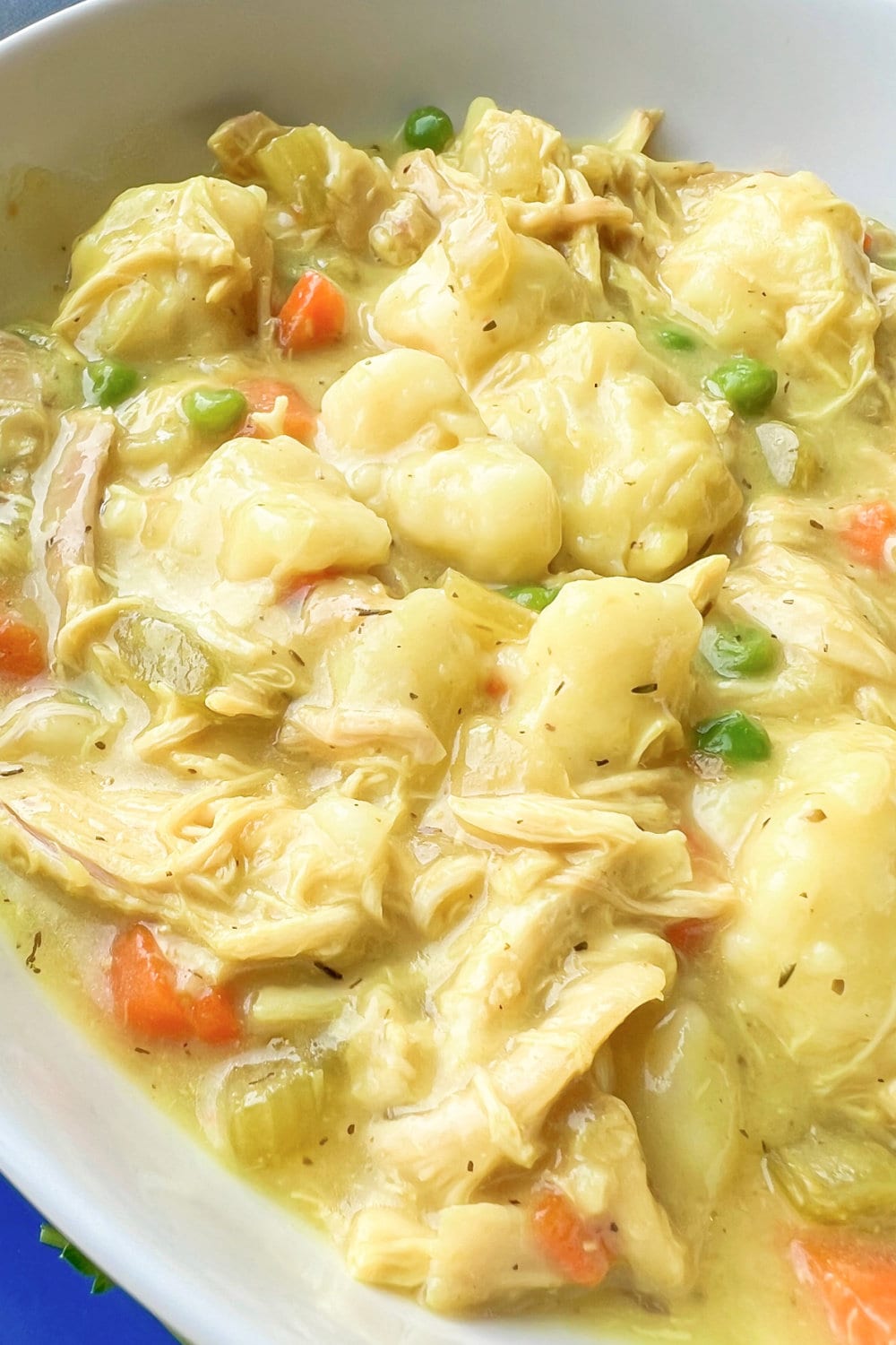 Warm chicken and dumplings in a white bowl, ready to be enjoyed.