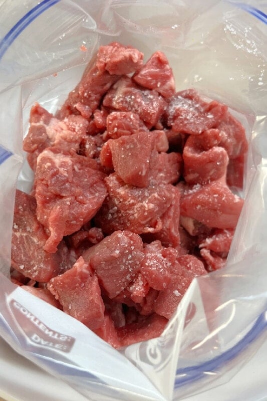 Cubed beef stew meat in a plastic freezer bag.