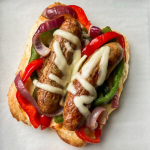 Air Fryer Chicken Sausages on a bed of roasted bell peppers and onions.