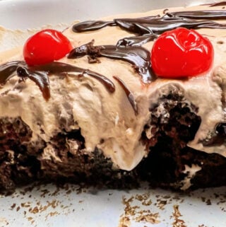 Chocolate Fudge Hot Cocoa Cake with cherries and fudge in a cake pan.