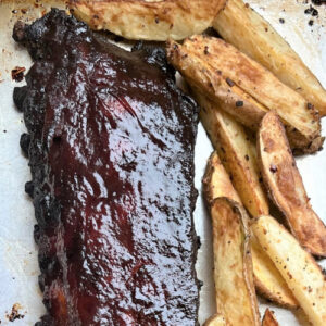 Sauced and caramelized baby back ribs with home fries.