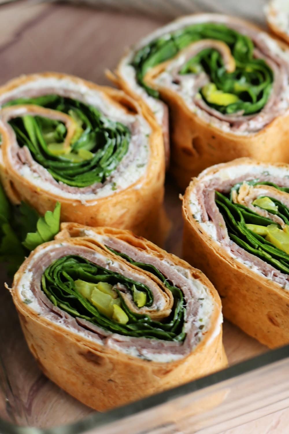 Roast beef roll ups in a glass serving dish. 