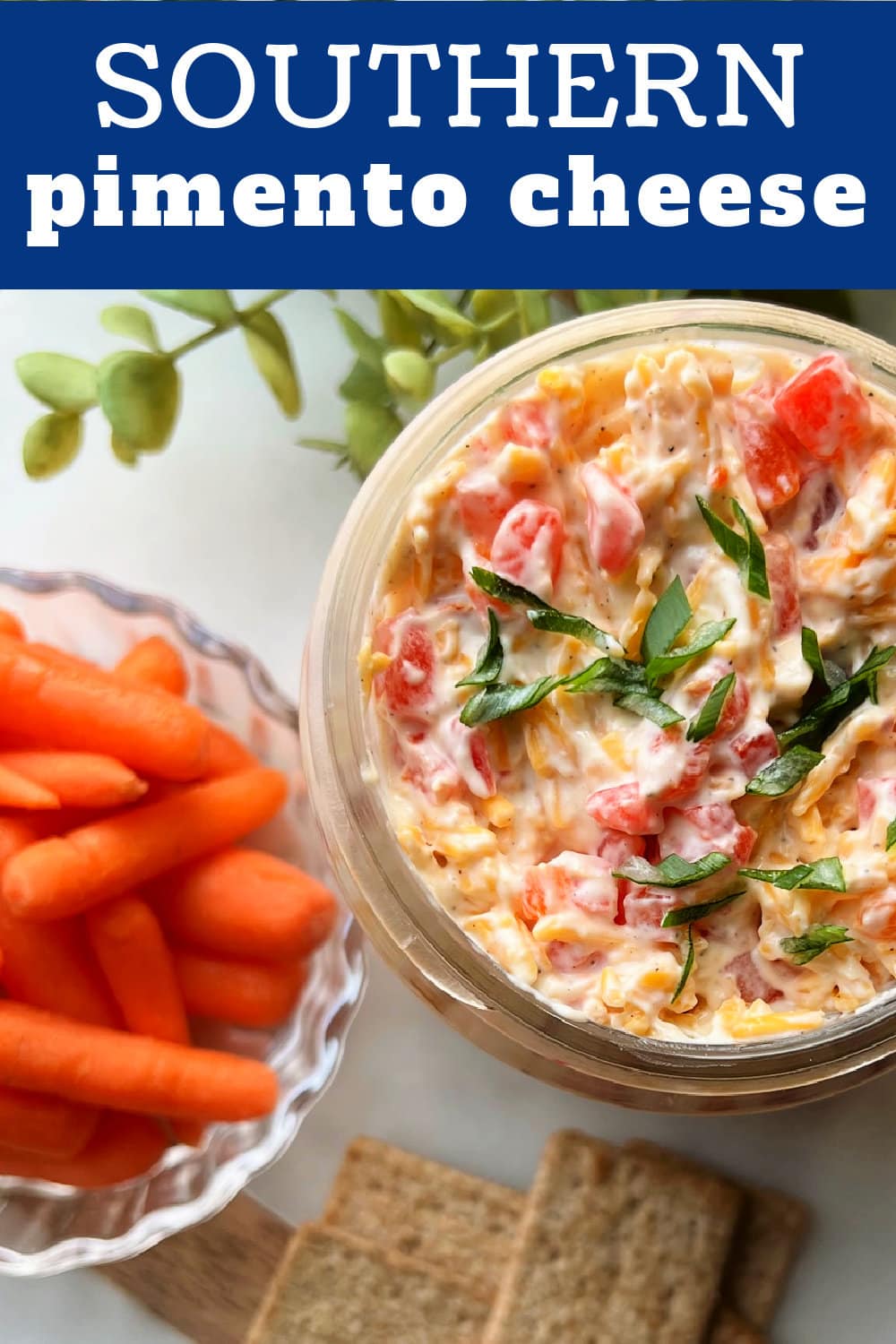 Pimento Cheese Spread in a glass jar with carrots on the side. 