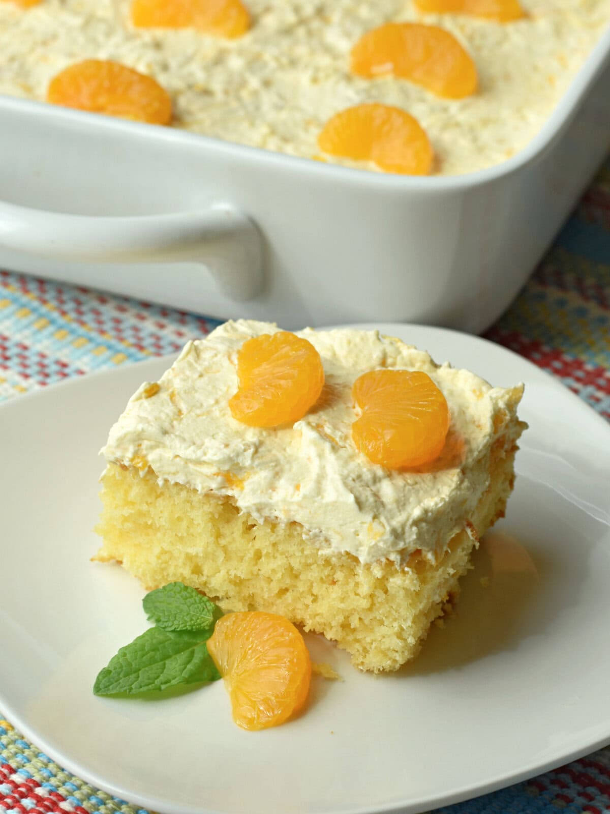 Sunshine cake with mayonnaise and crushed pineapple and mandarin oranges on a plate. 