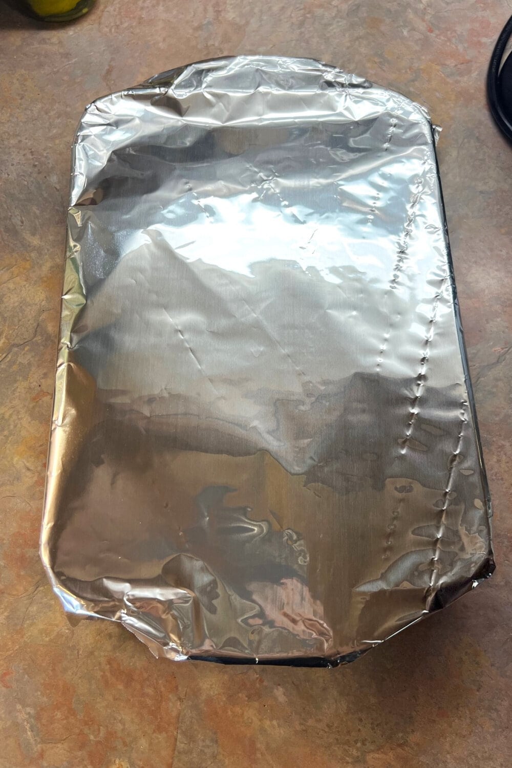 A warm cake covered with foil to rest and cool. 