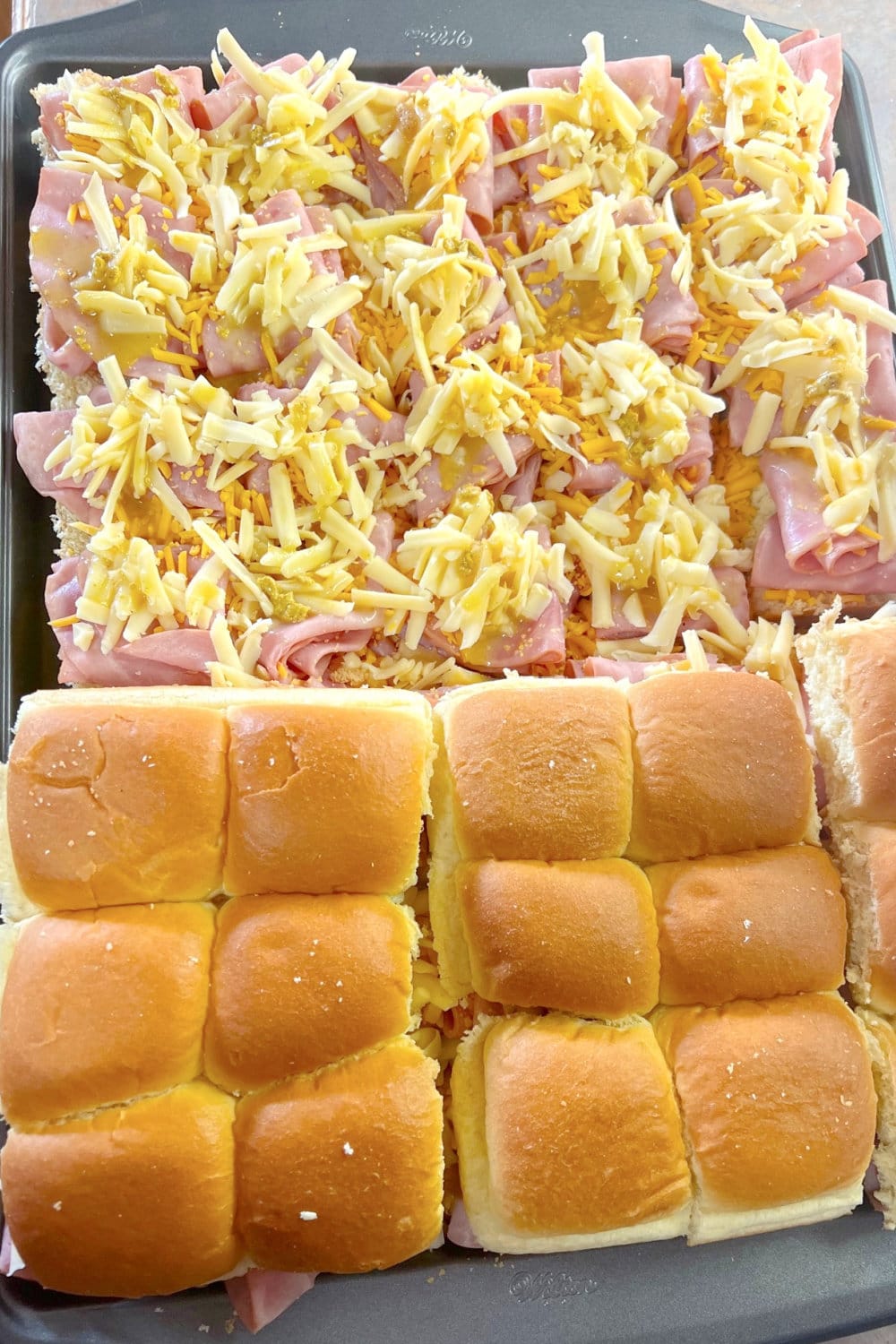 Preparing ham and cheese sliders for the oven. 