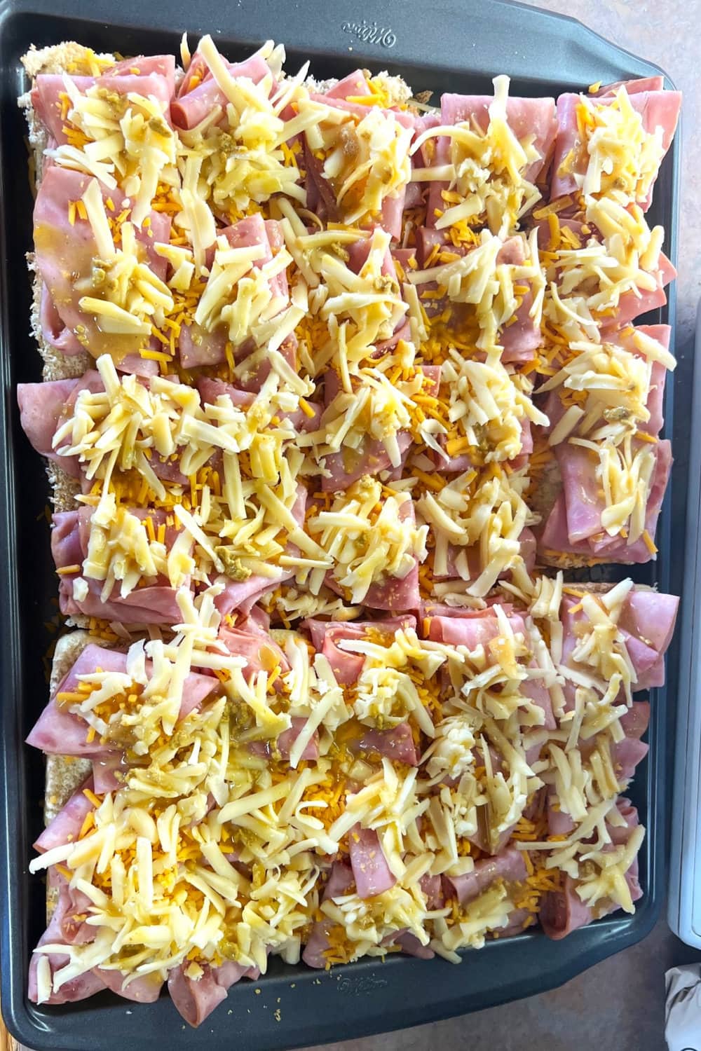 Ham and cheese on top of slider buns. 