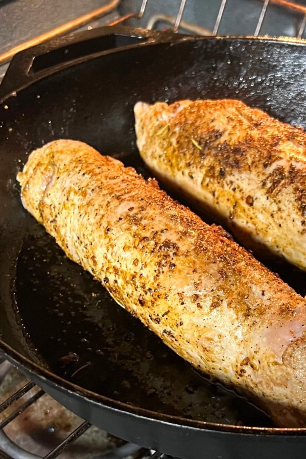 Seared pork tenderloins roasting in the oven. 