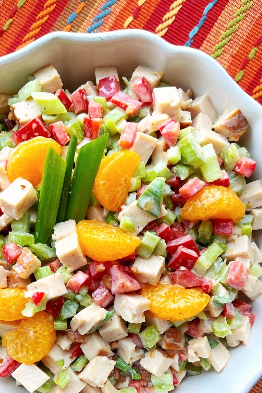 Chilled and ready, a large white bowl full of Tropical Turkey Salad. 