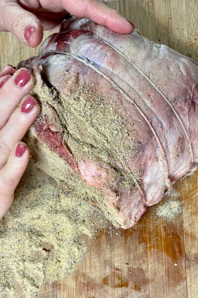 Applying the seasoning blend to the prime rib roast with fingertips. 