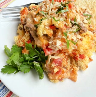 A serving of Cowboy Cornbread Casserole served with cilantro on a white plate.