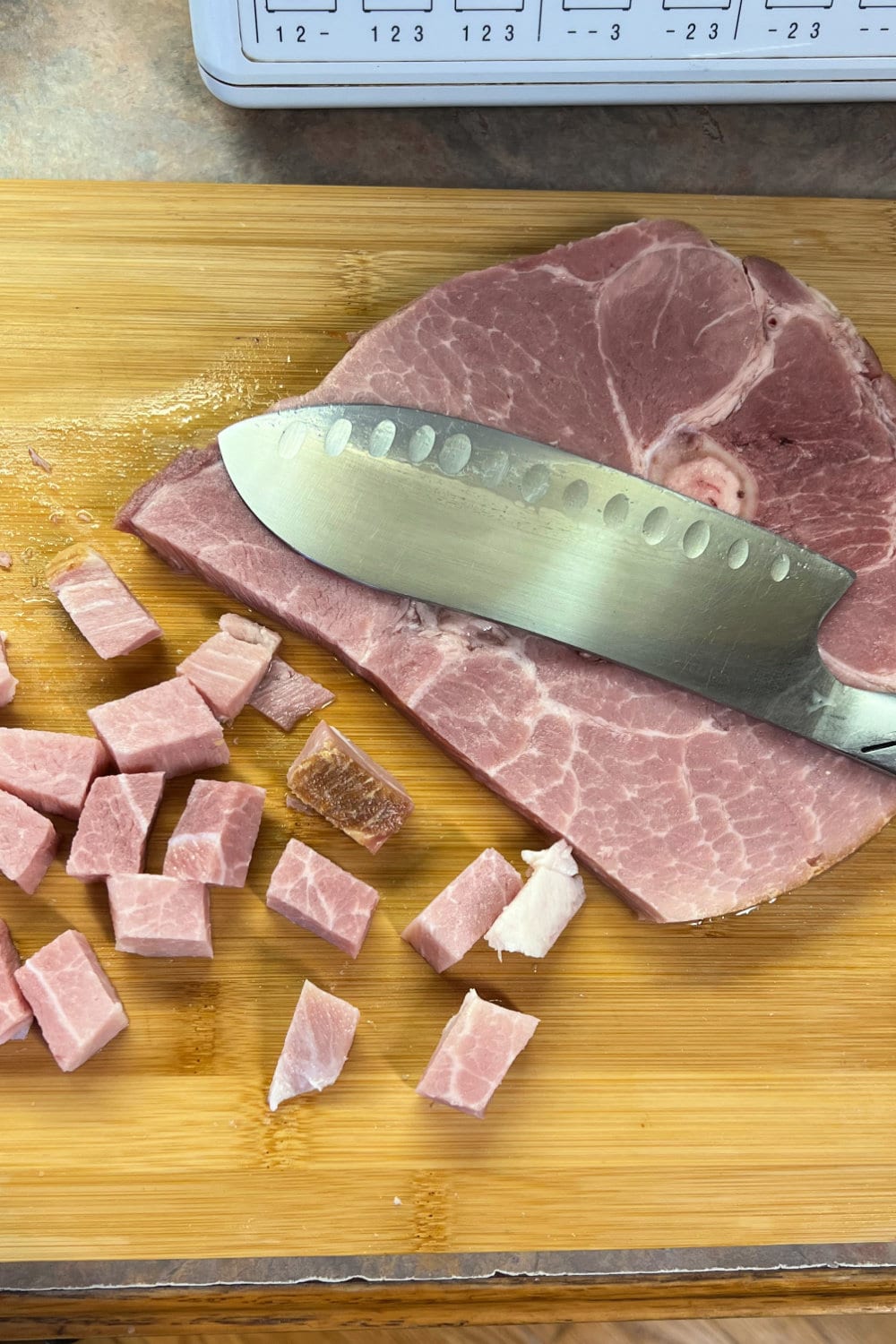 A ham steak on a cutting board, sliced into bite-sized pieces. 