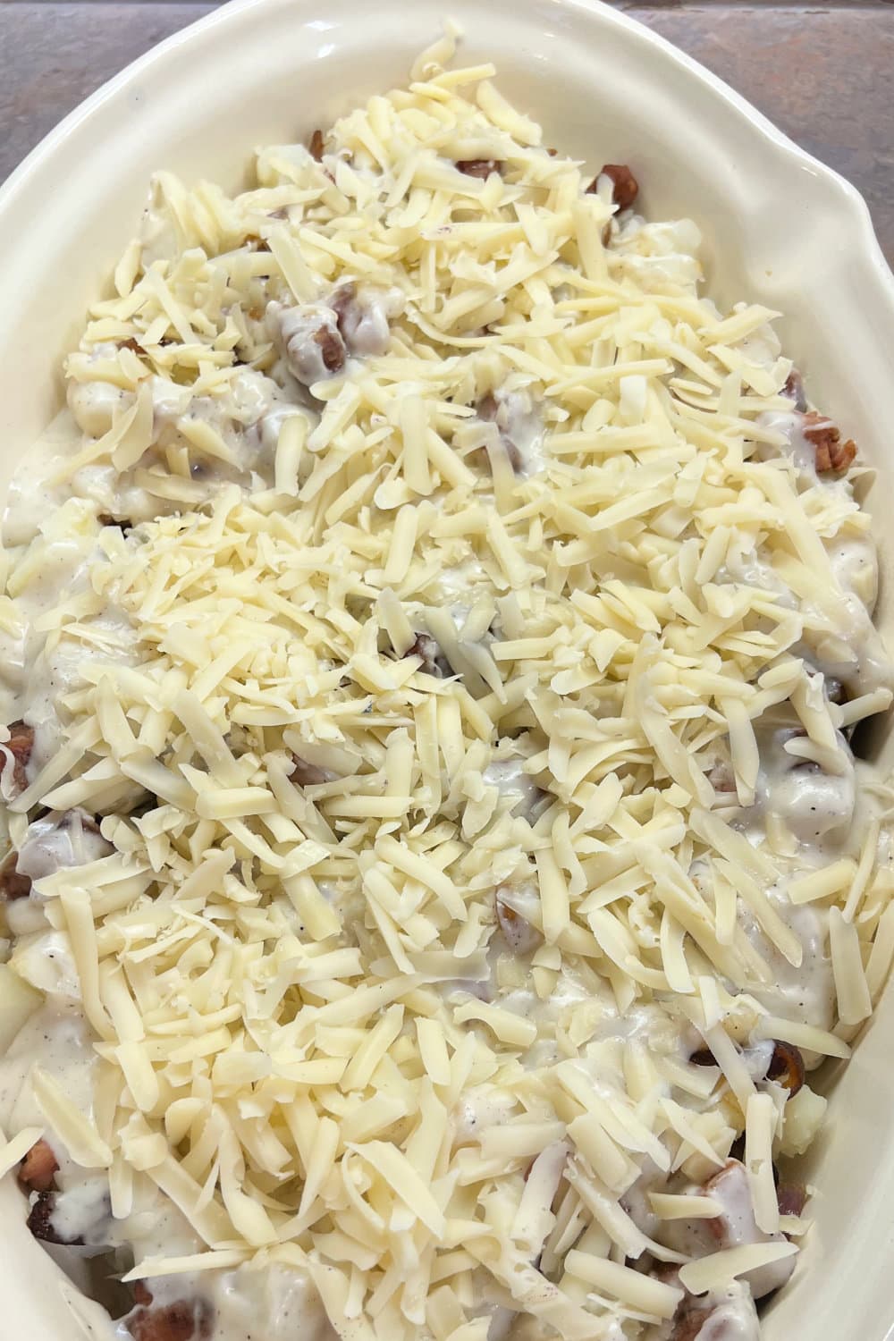 Shredded swiss cheese sprinkled over a creamy potato and ham bake. 