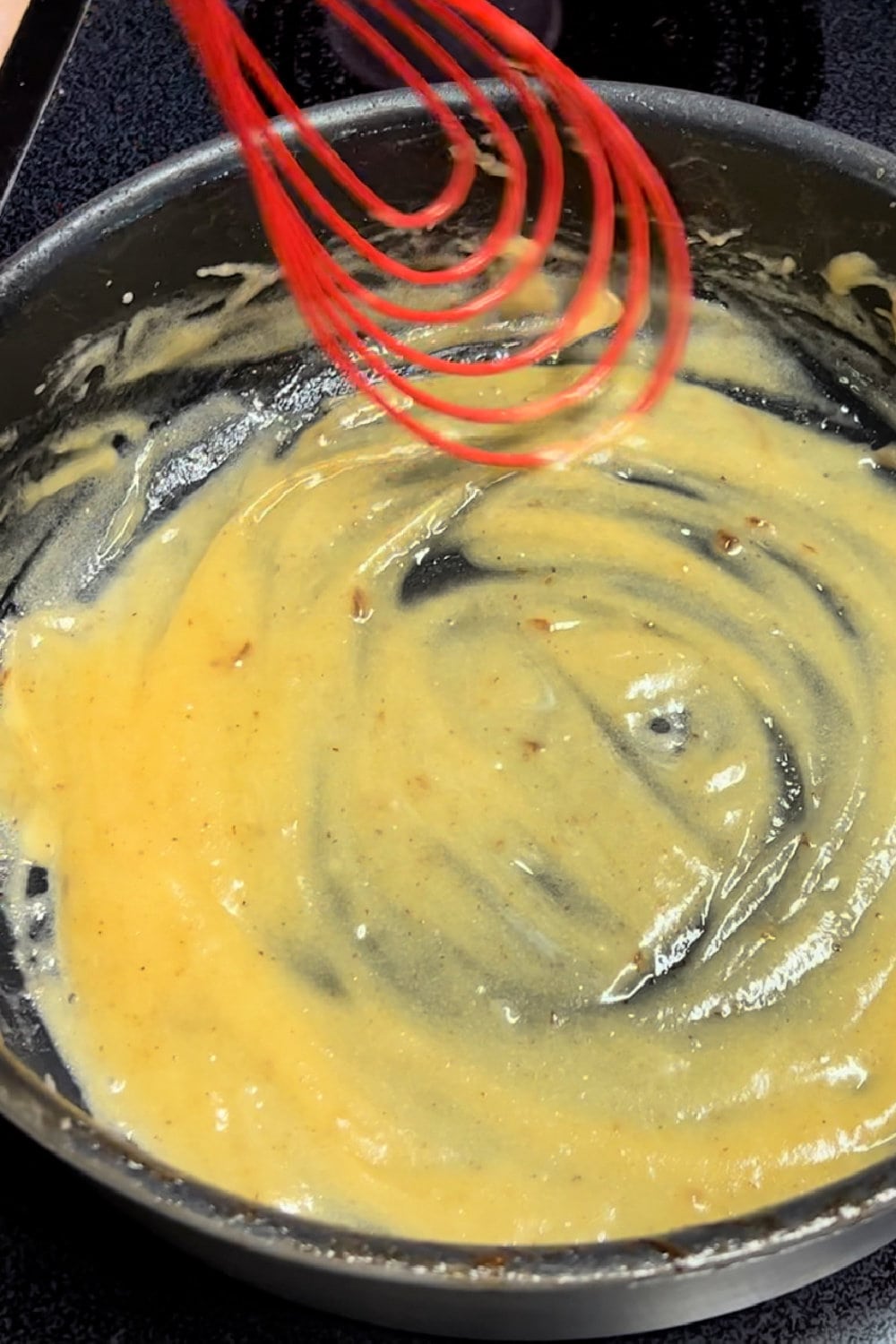 Whisking a golden brown roux in a skillet. 