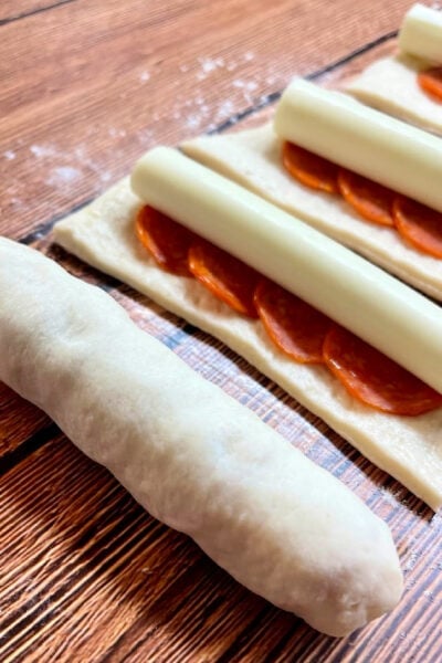 Wrapping the pizza dough around the bread stick filling. 