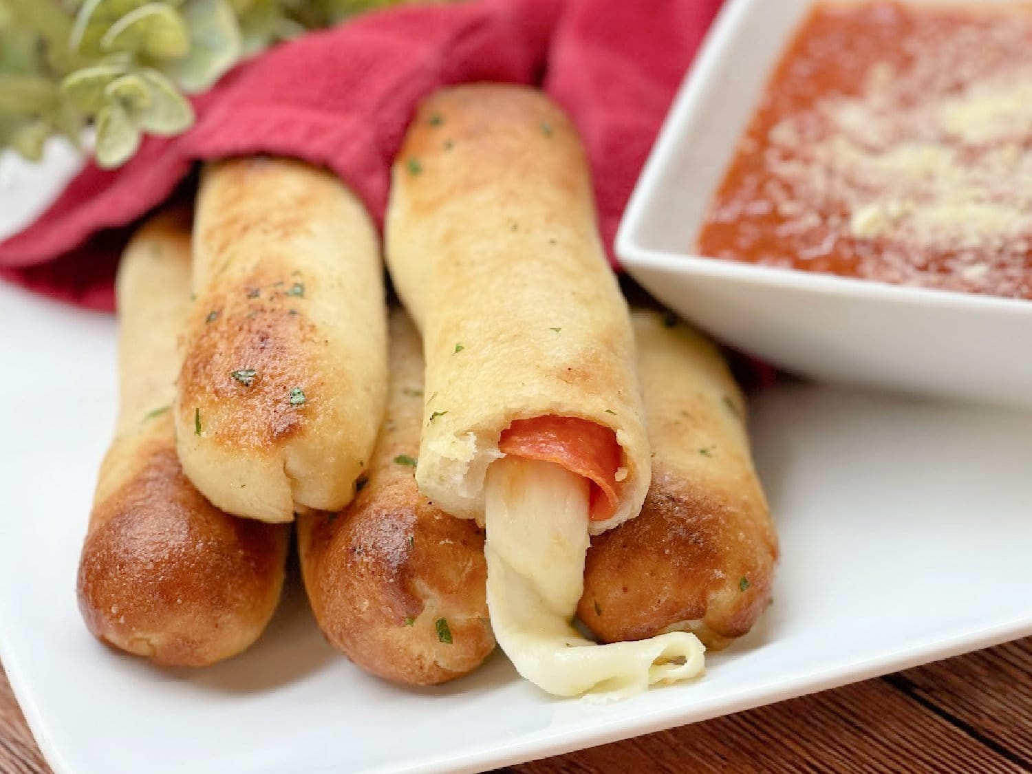 Air Fryer Pizza Breadsticks piled on a white plate. 