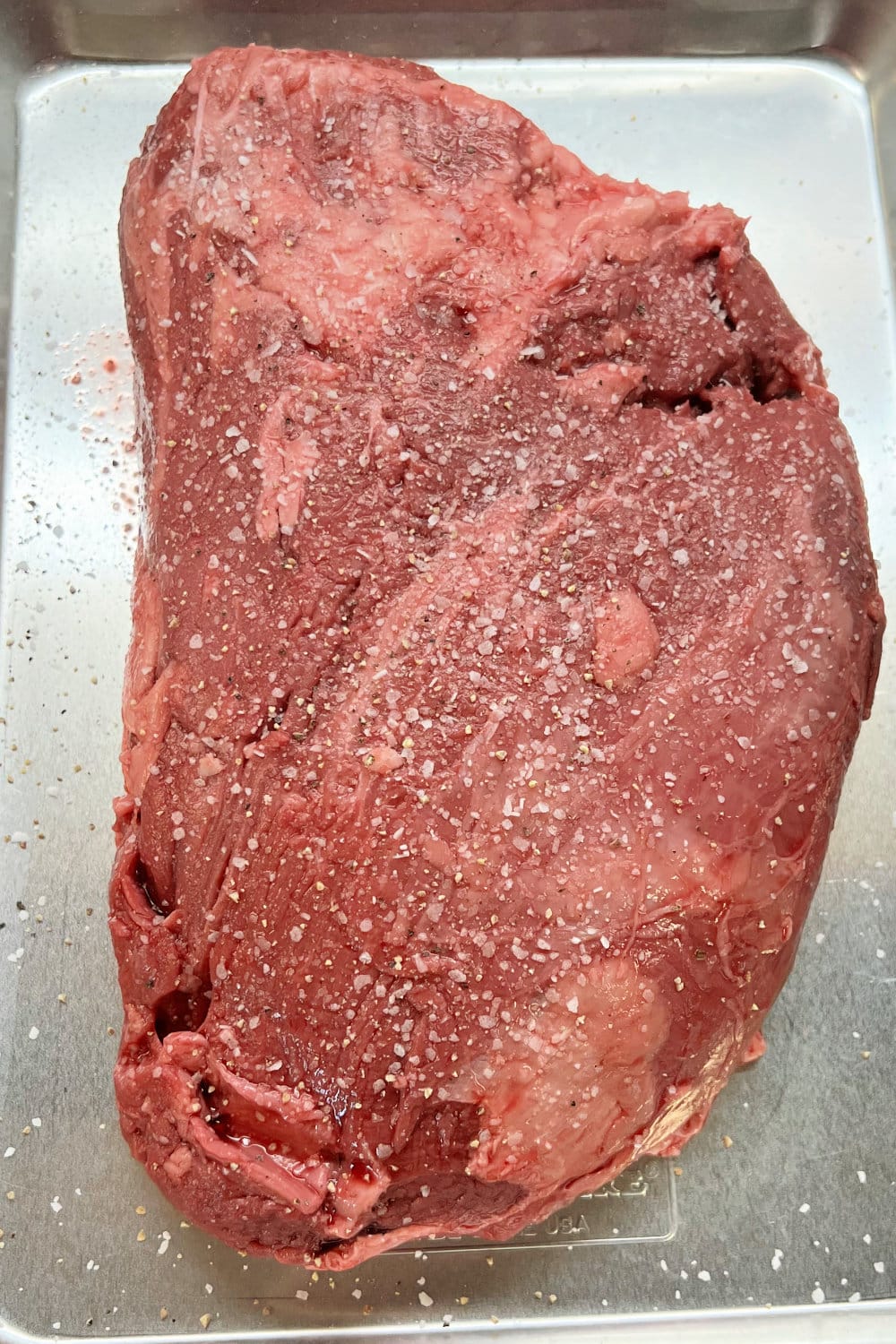 Seasoned beef tenderloin roast, ready to be seared in a skillet.