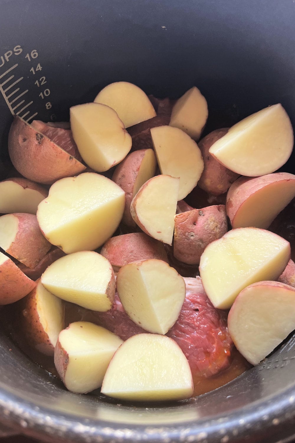 Red potatoes added to the rump roast in the Instant Pot. 