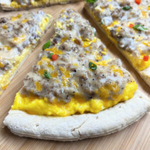 A nice big slice of Sausage Gravy Breakfast Pizza ready to eat.