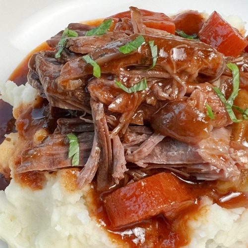 Shredded chuck tender roast with gravy over mashed potatoes.